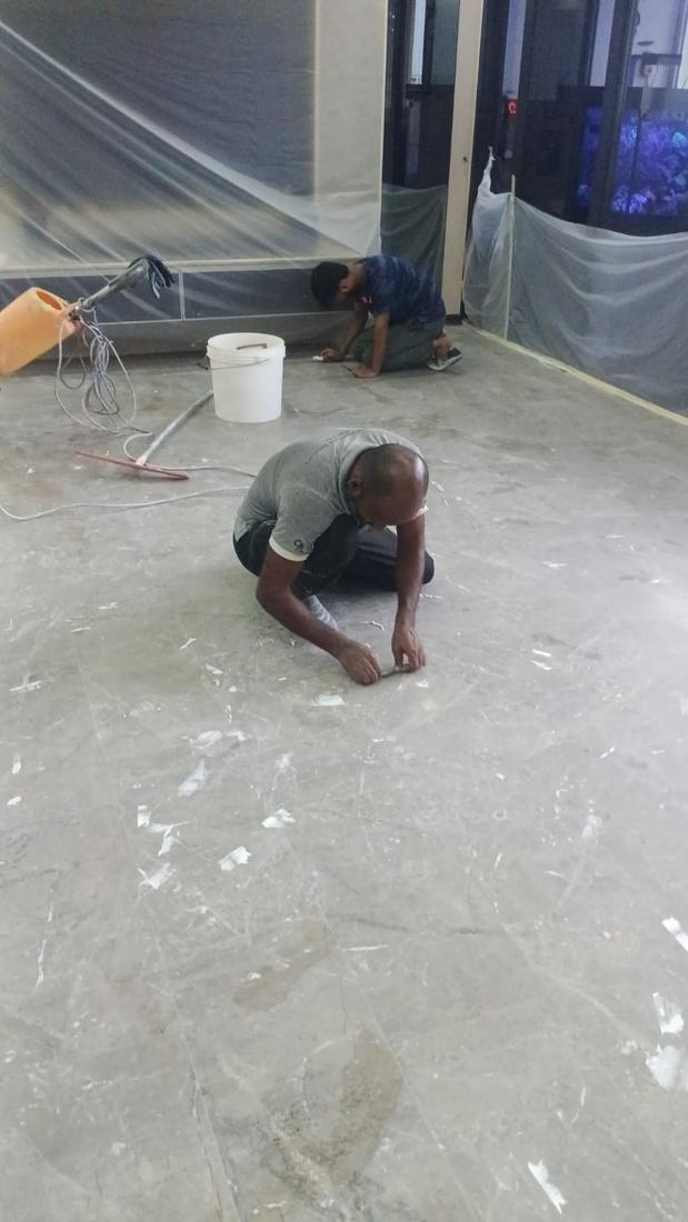 Technician working on marble joints with walls protected by plastic